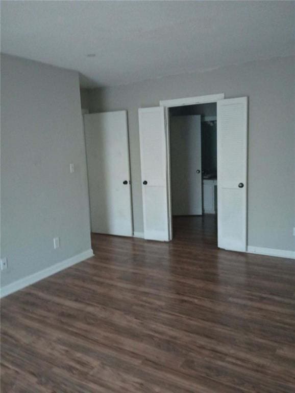 unfurnished bedroom featuring dark wood-type flooring and a closet