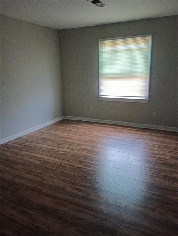 empty room with dark wood-type flooring