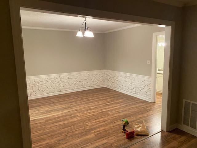 172 Rue Fontaine, Lithonia, GA 30038 - empty room featuring dark wood finished floors, ornamental molding, wainscoting, and a chandelier