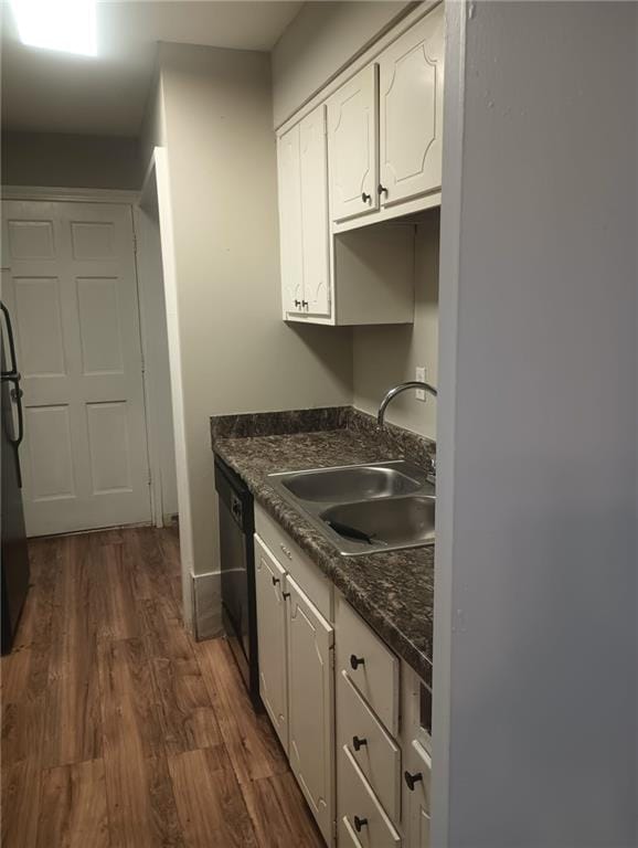 kitchen featuring dark stone counters, dark hardwood / wood-style flooring, sink, white cabinets, and dishwasher