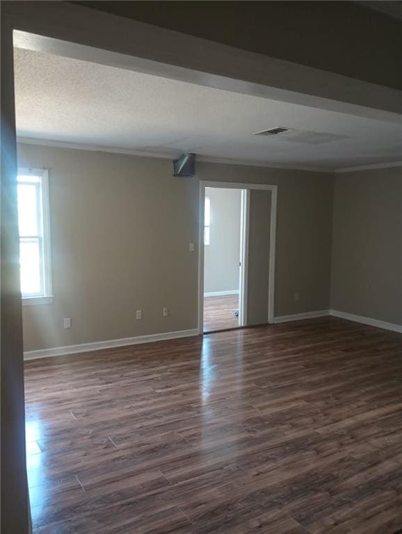 empty room with dark wood-type flooring and crown molding