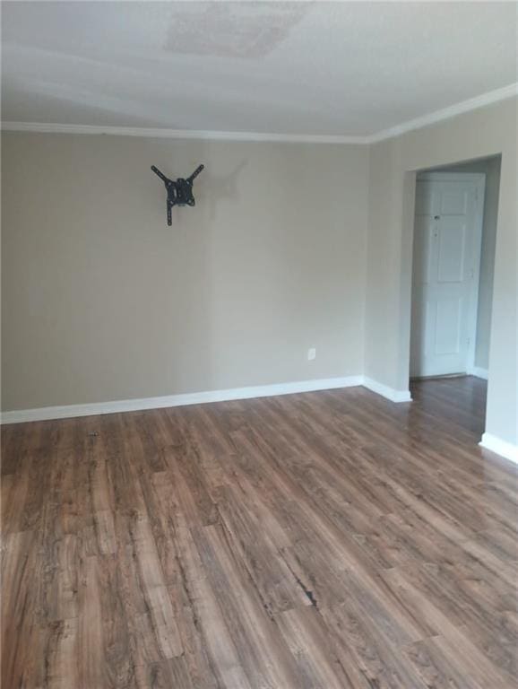 empty room with ornamental molding and hardwood / wood-style floors