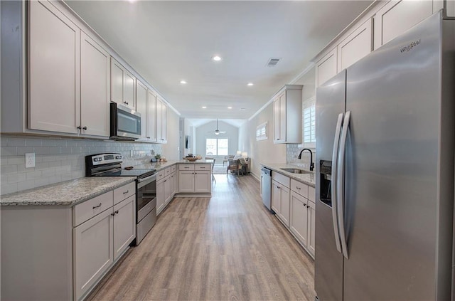 46 Courtyard Ln, Cartersville, GA 30120 - kitchen with appliances with stainless steel finishes, light wood-style flooring, a peninsula, backsplash, and open floor plan