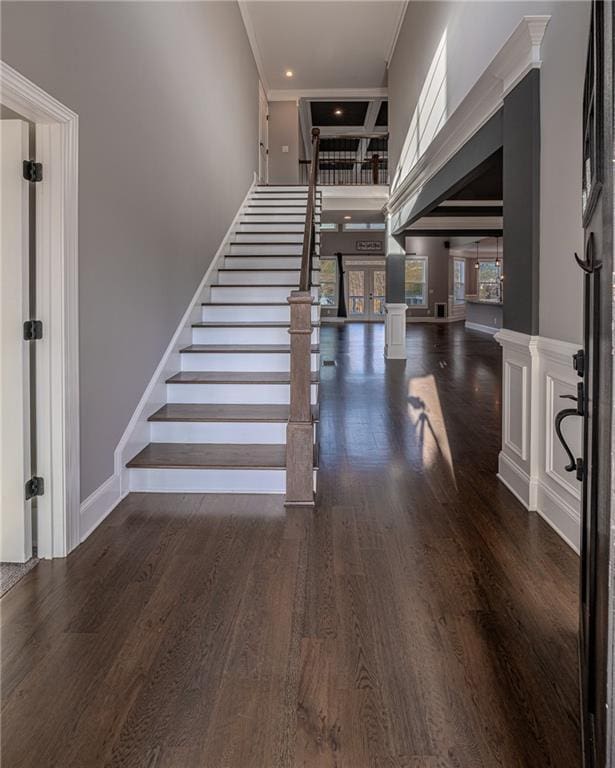 staircase with hardwood / wood-style floors, ornamental molding, and a wealth of natural light