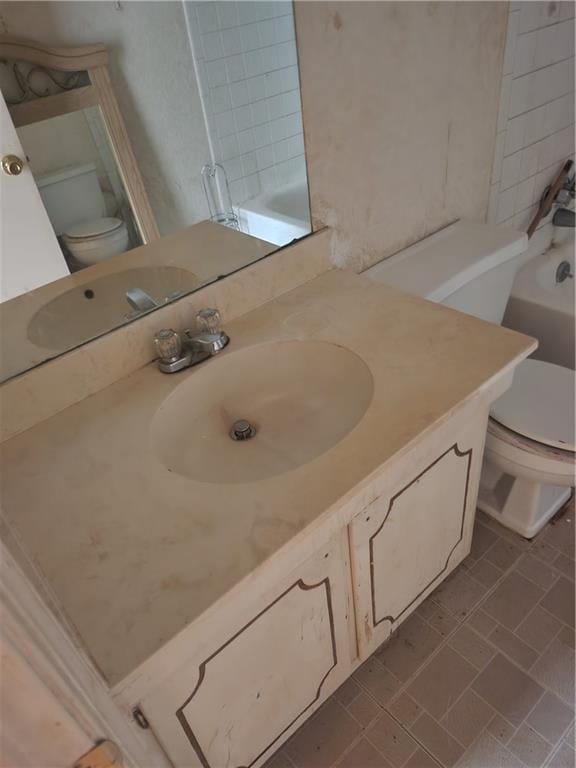 bathroom with vanity, a tub, toilet, and tile patterned flooring