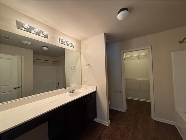 837 Castilla Way, Winder, GA 30680 - full bathroom with vanity, wood finished floors, a walk in closet, and washtub / shower combination