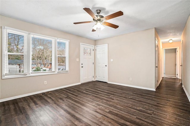 unfurnished room featuring dark wood-type flooring and ceiling fan