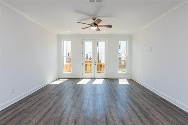 empty room with dark wood-type flooring, visible vents, baseboards, ornamental molding, and french doors