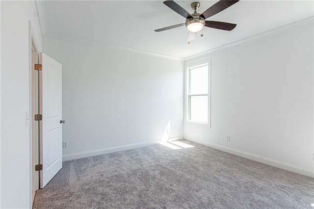 empty room featuring a ceiling fan, carpet flooring, crown molding, and baseboards