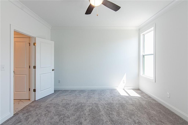 unfurnished room featuring carpet floors, crown molding, baseboards, and ceiling fan