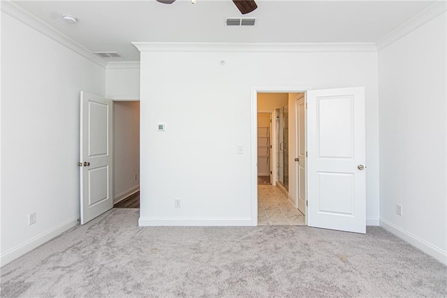 unfurnished bedroom with baseboards, visible vents, carpet flooring, and ornamental molding