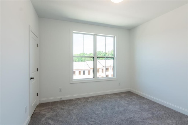 carpeted spare room featuring baseboards