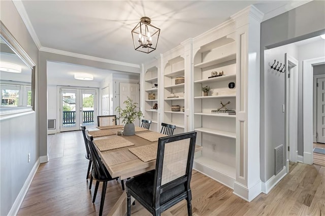 dining space with visible vents, baseboards, french doors, ornamental molding, and light wood finished floors