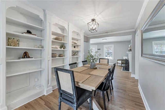 dining area featuring baseboards, plenty of natural light, an inviting chandelier, and wood finished floors