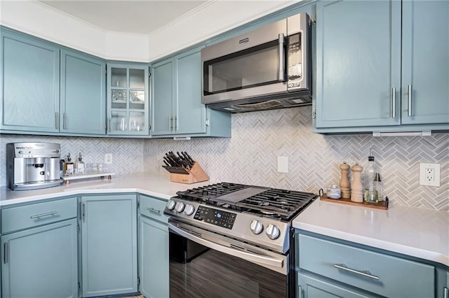 kitchen with stainless steel appliances, light countertops, and blue cabinets