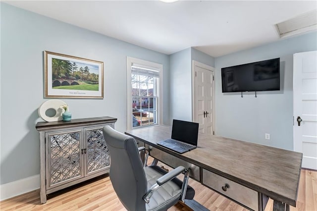 office space with light wood-style flooring, attic access, and baseboards