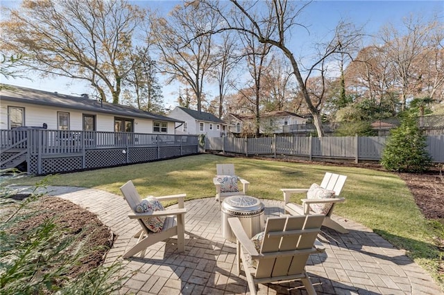 view of patio / terrace featuring an outdoor fire pit, fence, and a deck