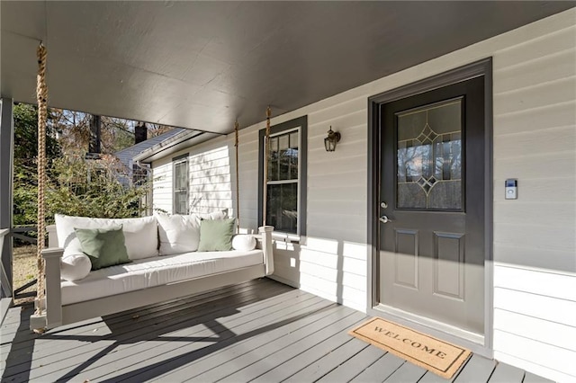 wooden deck featuring covered porch and an outdoor living space