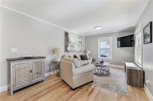 living room featuring ornamental molding, wood finished floors, and baseboards