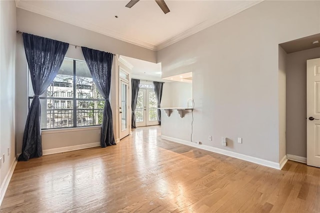 empty room featuring french doors, ceiling fan, ornamental molding, and light wood-type flooring