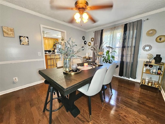 dining space with ornamental molding, dark wood-type flooring, and ceiling fan