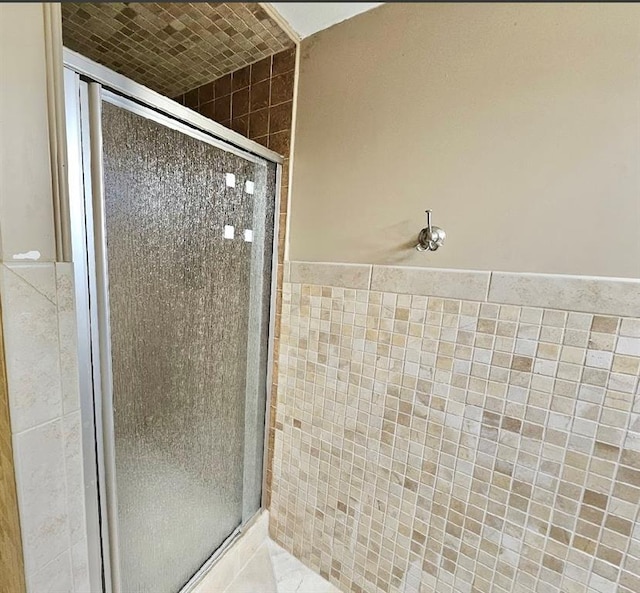 bathroom with tile walls and walk in shower