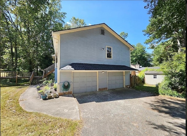 view of property exterior featuring a garage and a storage shed