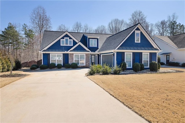 craftsman-style home featuring a front lawn, driveway, and an attached garage