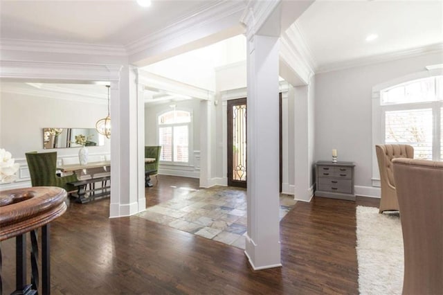 entrance foyer featuring decorative columns, wood finished floors, baseboards, and ornamental molding