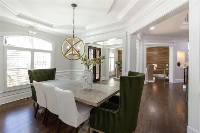 dining room with a chandelier, healthy amount of natural light, crown molding, a tray ceiling, and dark wood finished floors