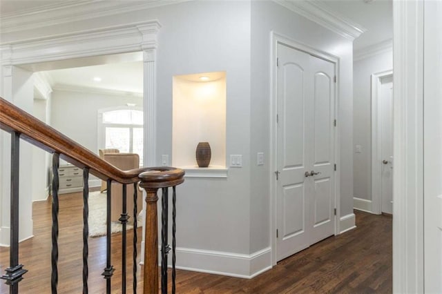 hallway featuring crown molding, dark wood-type flooring, baseboards, and stairs