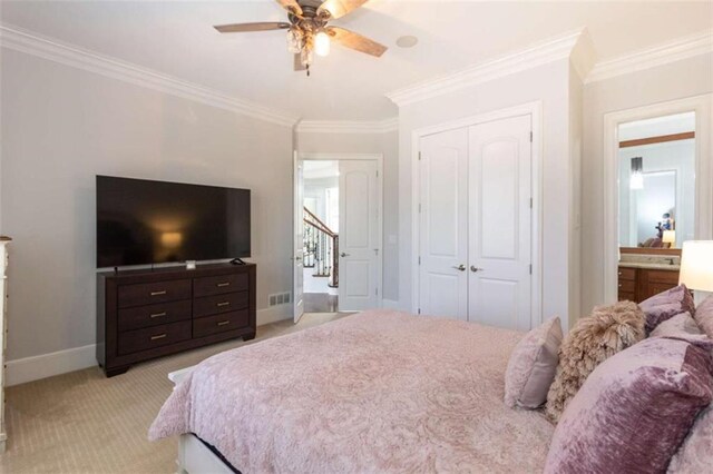 bedroom with ornamental molding, light colored carpet, a closet, baseboards, and ceiling fan