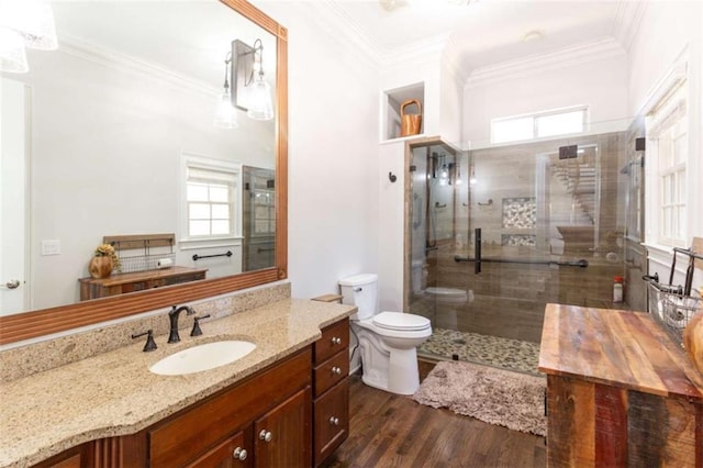 full bathroom featuring healthy amount of natural light, crown molding, wood finished floors, a tile shower, and toilet