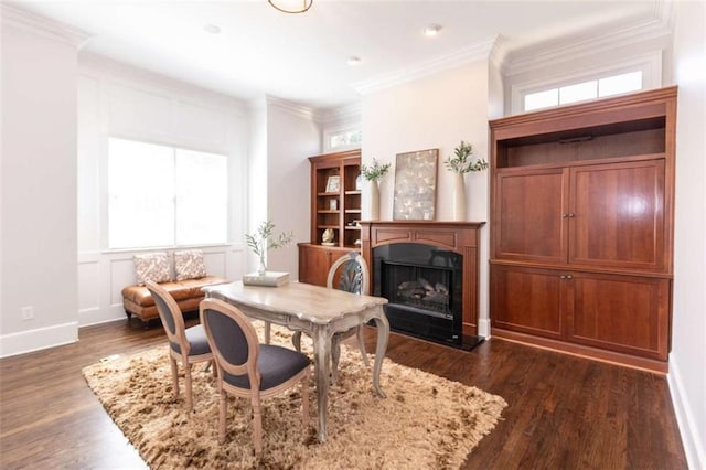 dining space featuring a fireplace with raised hearth, crown molding, dark wood finished floors, and baseboards