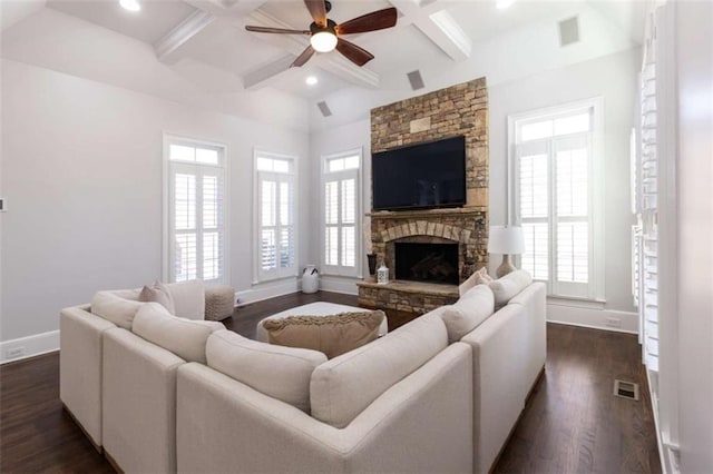 living area featuring a ceiling fan, baseboards, a fireplace, beam ceiling, and dark wood-style flooring