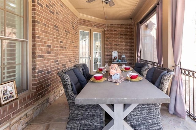 dining room with crown molding, brick wall, a ceiling fan, and wooden ceiling
