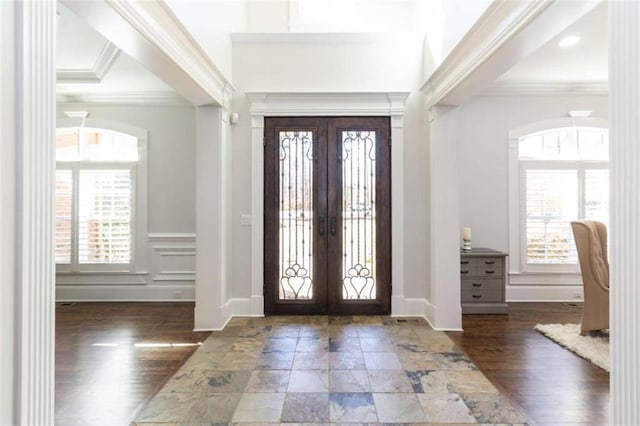 foyer with french doors, crown molding, and wood finished floors