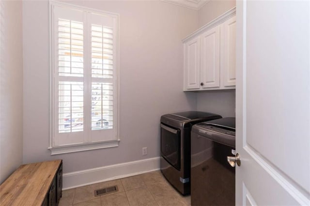 laundry area with separate washer and dryer, cabinet space, light tile patterned floors, and baseboards