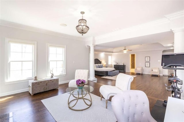 living area featuring decorative columns, crown molding, dark wood-style flooring, and baseboards