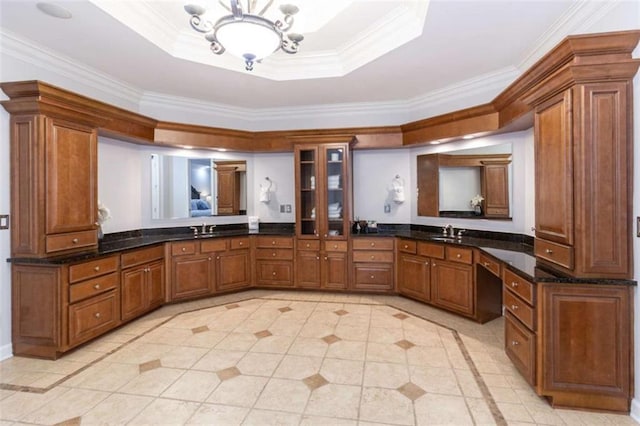 bathroom with crown molding, inlaid floor details, a tray ceiling, double vanity, and tile patterned floors
