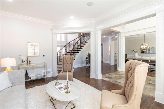 living area featuring crown molding, stairway, wood finished floors, decorative columns, and a chandelier