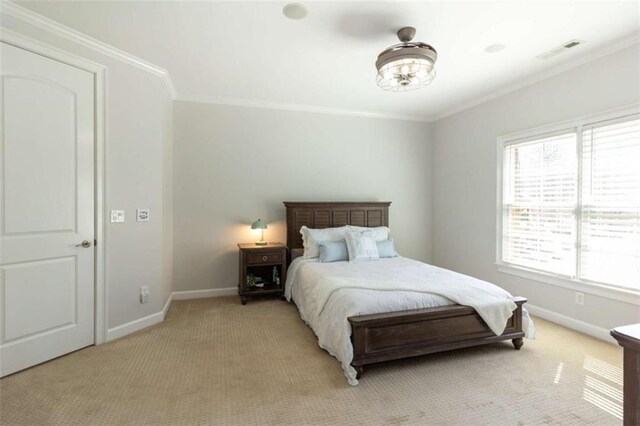 bedroom featuring light carpet, baseboards, and crown molding