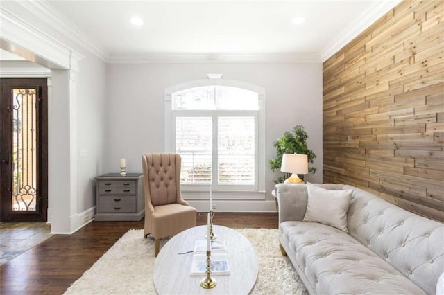 living room with wood walls, an accent wall, baseboards, dark wood-style floors, and recessed lighting