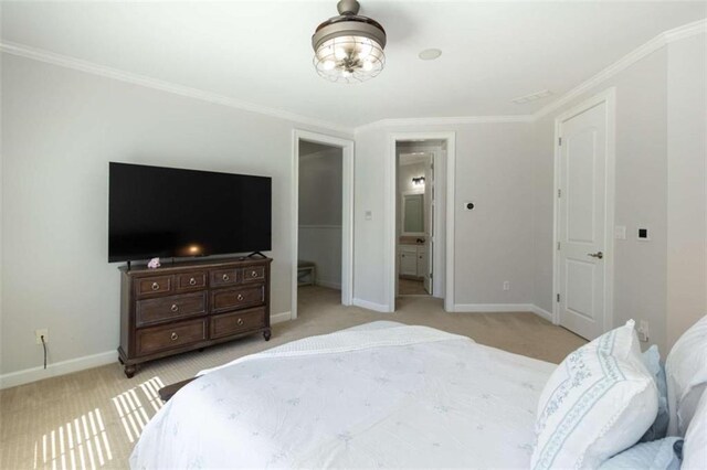 bedroom with baseboards, carpet, ornamental molding, and ensuite bath
