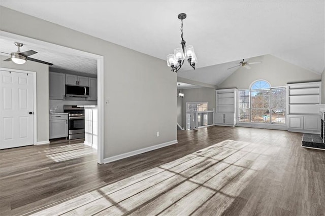 unfurnished living room with ceiling fan with notable chandelier, vaulted ceiling, and dark hardwood / wood-style floors