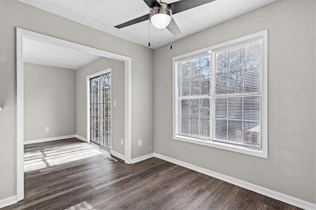 empty room featuring dark wood-type flooring, ceiling fan, and a textured ceiling