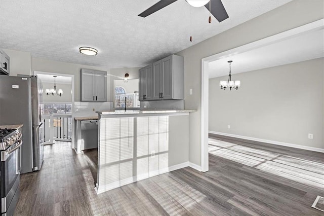 kitchen with gray cabinets, stainless steel appliances, dark hardwood / wood-style floors, tasteful backsplash, and a textured ceiling