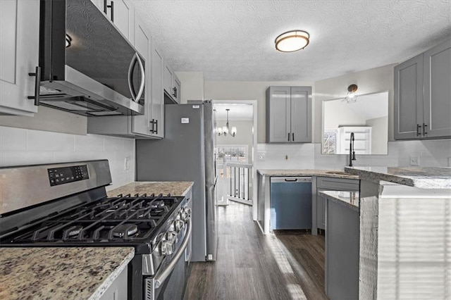 kitchen featuring sink, backsplash, gray cabinets, and appliances with stainless steel finishes