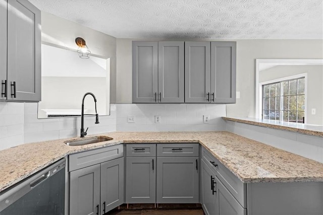 kitchen featuring stainless steel dishwasher, gray cabinets, and sink