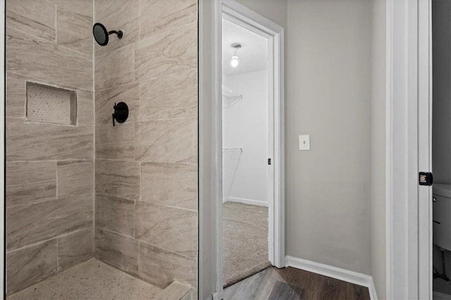 bathroom featuring hardwood / wood-style flooring and tiled shower